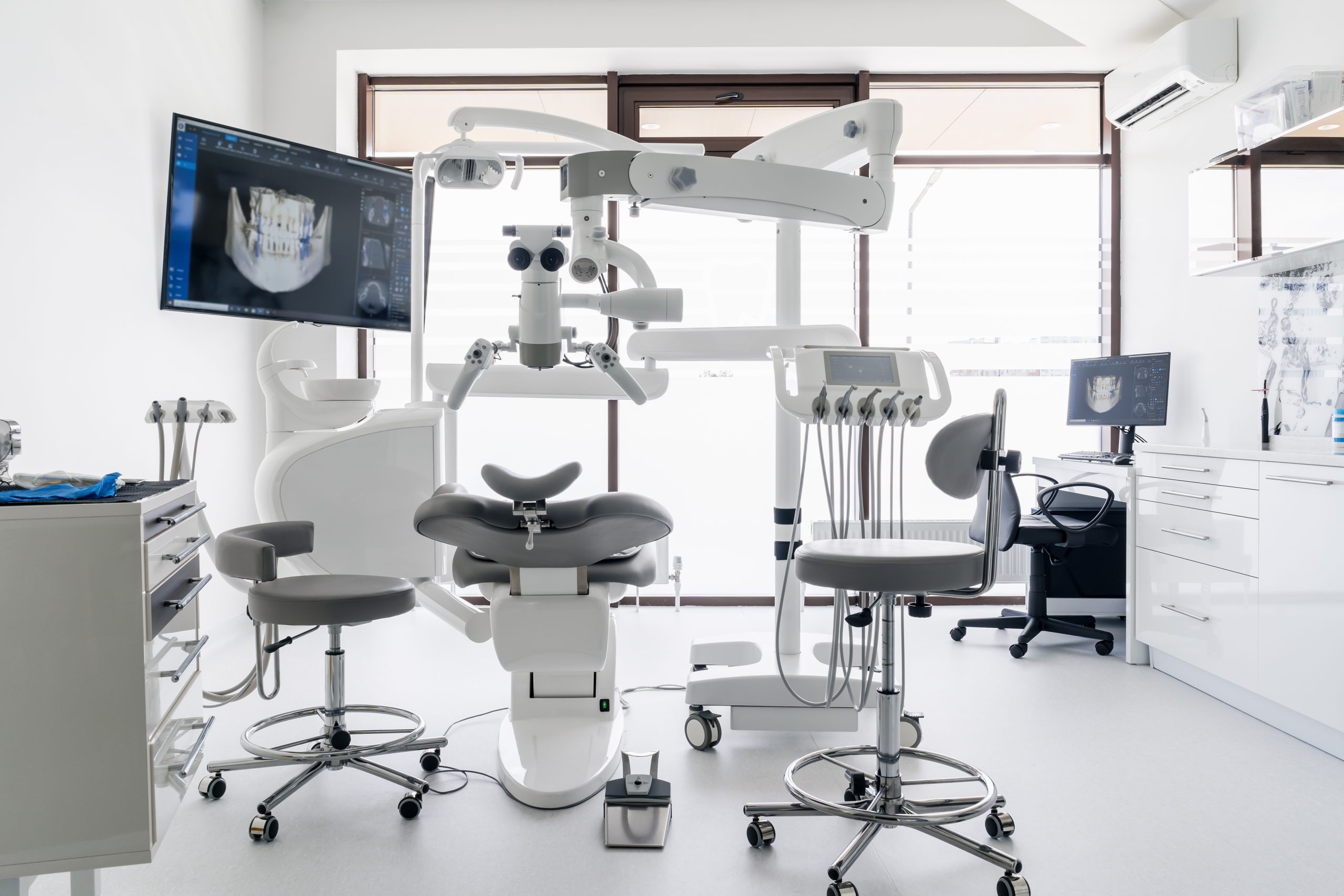 Interior of dental practice room with chair, lamp, display and stomatological tools
